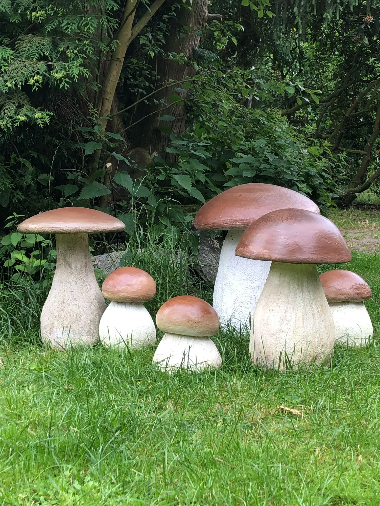Gruppe von fünf Steinpilz-Skulpturen aus Beton im Garten
